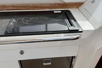 2022 Nimbus W9 boat kitchen with stove and storage, featuring sleek design and modern amenities.