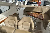 2022 Nimbus W9 boat interior with beige seating and wooden accents at a marina.