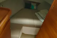 Cozy cabin interior of 2022 Nimbus W9 boat with bed and wooden furnishings.
