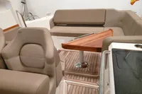 Luxurious interior of 2022 Nimbus W9 boat with beige seating and wooden table.