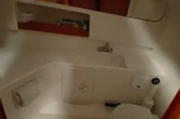 Compact bathroom in 2022 Nimbus W9 boat with sink, toilet, and storage.
