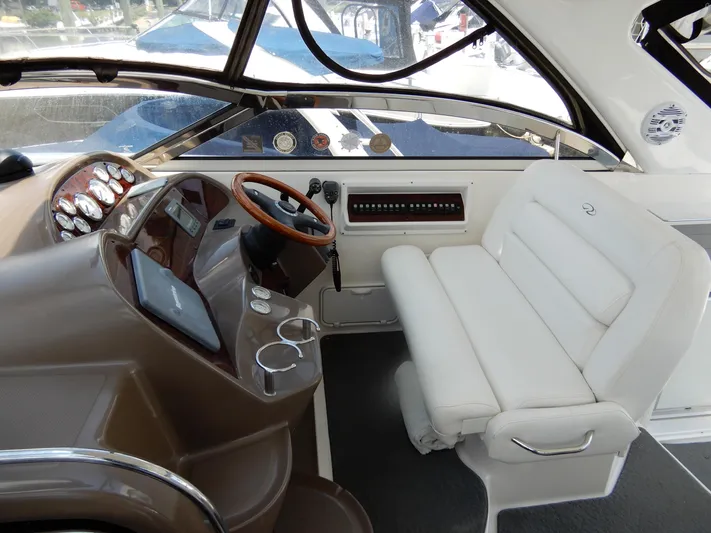  Yacht Photos Pics 2006 Regal Commodore 3760 IO boat cockpit with white seating and wooden steering wheel.