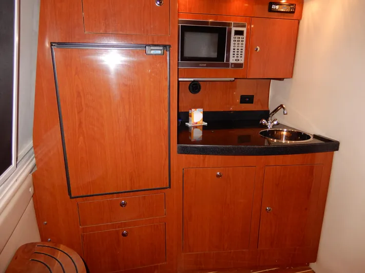  Yacht Photos Pics 2006 Regal Commodore 3760 IO yacht kitchenette with wood cabinetry, microwave, and sink.