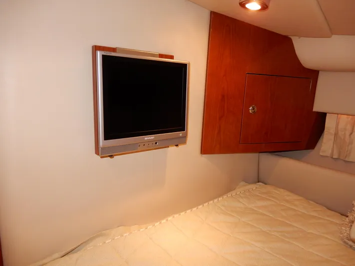  Yacht Photos Pics 2006 Regal Commodore 3760 IO cabin with wall-mounted TV and cozy bedding.