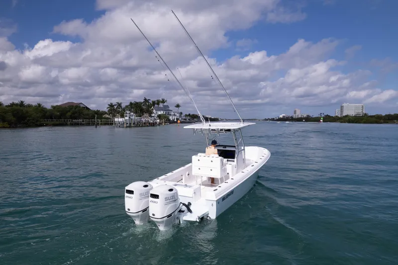  Yacht Photos Pics 2024 Bluewater 2550 boat cruising on a scenic waterway under a partly cloudy sky.