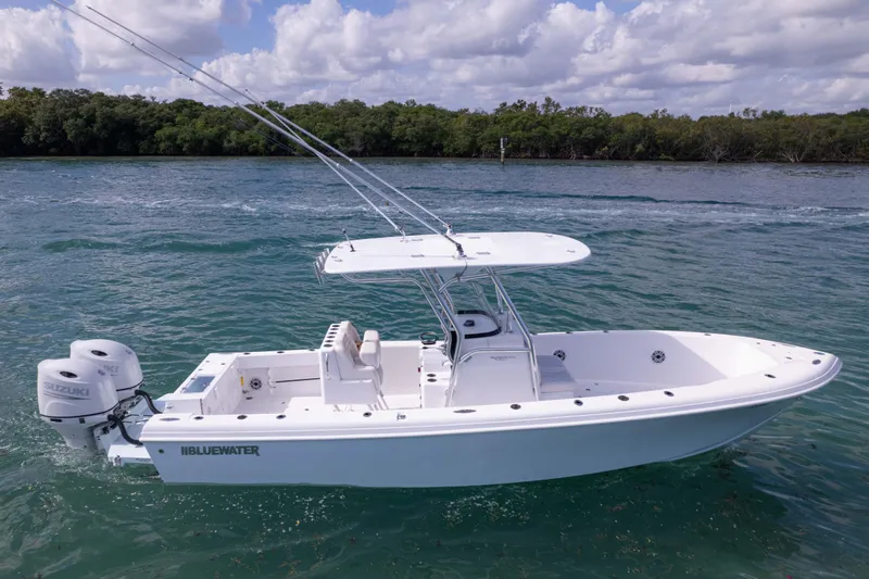  Yacht Photos Pics 2024 Bluewater 2550 boat on water, featuring dual Suzuki engines, under a cloudy sky.