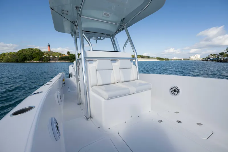  Yacht Photos Pics 2024 Bluewater 2550 boat interior with seating, on calm water near a lighthouse.