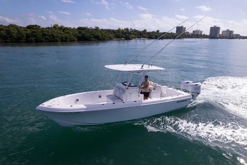  Yacht Photos Pics 2024 Bluewater 2550 boat cruising on a sunny day with lush shoreline in the background.
