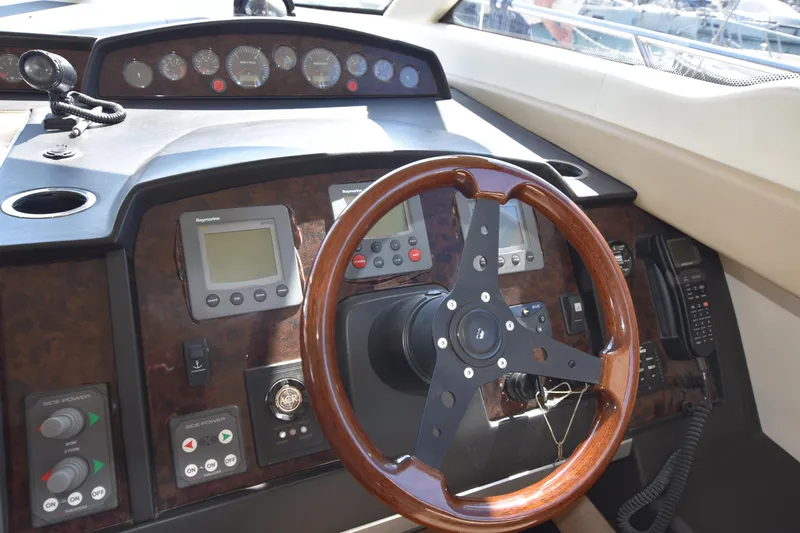 Spirit Bear Yacht Photos Pics Steering wheel and dashboard of a 2006 Princess 50 yacht, featuring navigation instruments.