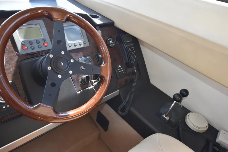 Spirit Bear Yacht Photos Pics Helm of 2006 Princess 50 yacht with wooden steering wheel and control panel.