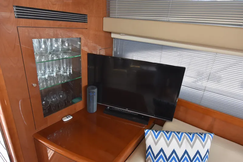 Spirit Bear Yacht Photos Pics Interior of 2006 Princess 50 yacht with TV, glass cabinet, and decorative pillow.