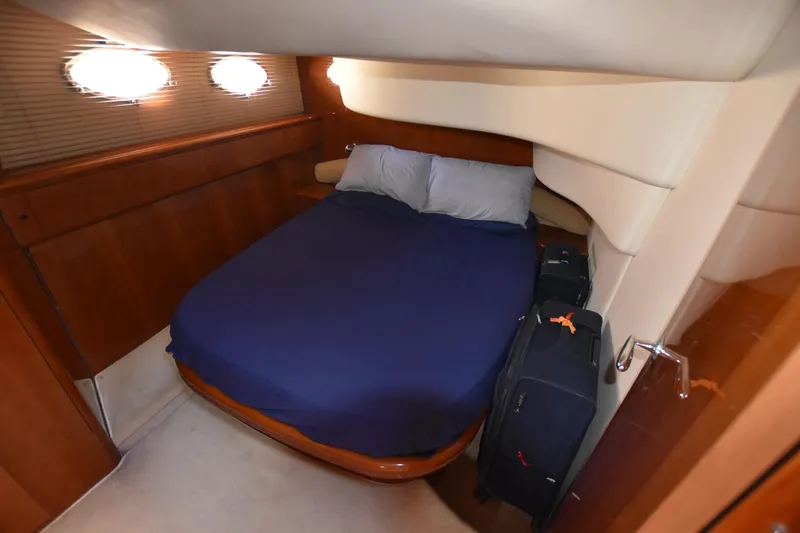 Spirit Bear Yacht Photos Pics Cozy cabin interior of 2006 Princess 50 yacht with bed and luggage.