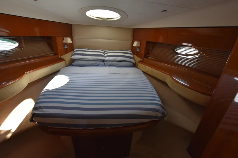 Spirit Bear Yacht Photos Pics Luxurious cabin interior of 2006 Princess 50 yacht with striped bedding and wooden accents.