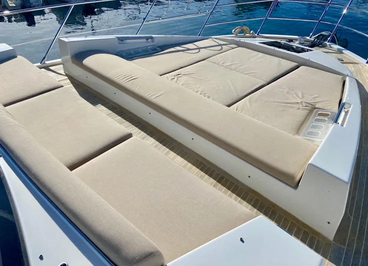  Yacht Photos Pics Luxurious sunbathing area on a 2012 Azimut 55S yacht, featuring comfortable beige cushions.