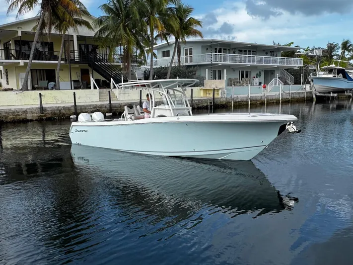  Yacht Photos Pics 2022 Sailfish 290 CC boat docked near waterfront homes with palm trees.