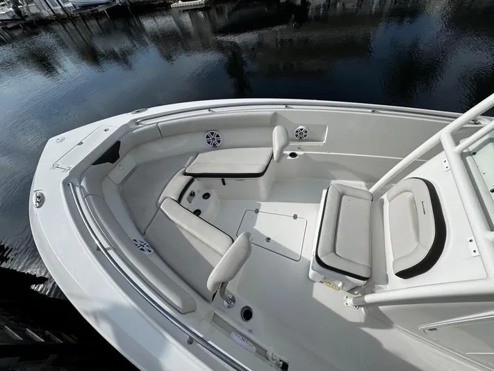  Yacht Photos Pics 2022 Sailfish 290 CC boat interior with seating, docked by calm water.