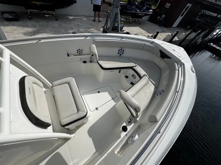  Yacht Photos Pics 2022 Sailfish 290 CC boat interior with cushioned seating and speakers, docked by the water.