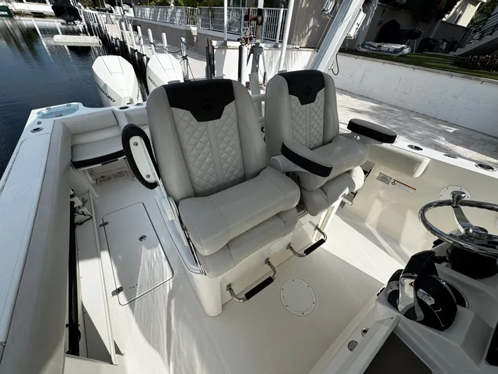  Yacht Photos Pics 2022 Sailfish 290 CC boat interior with dual cushioned seats and steering wheel.
