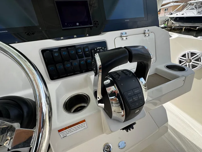  Yacht Photos Pics Control panel of 2022 Sailfish 290 CC boat with steering wheel and throttle.