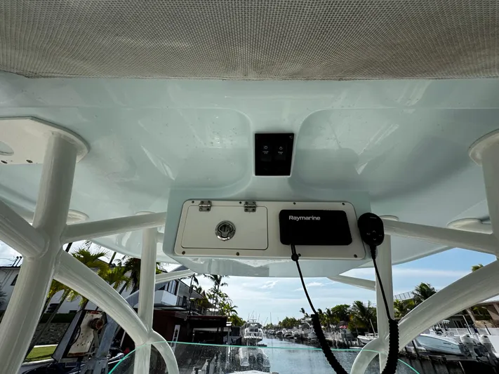  Yacht Photos Pics 2022 Sailfish 290 CC boat console with Raymarine equipment, docked near waterfront homes.