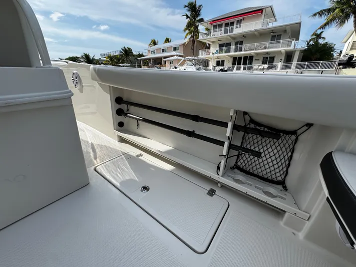 Yacht Photos Pics 2022 Sailfish 290 CC boat interior with rod storage and netting, docked near waterfront homes.