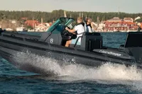 2023 Nordkapp AIRBORNE 8 speedboat cruising on water near coastal village.
