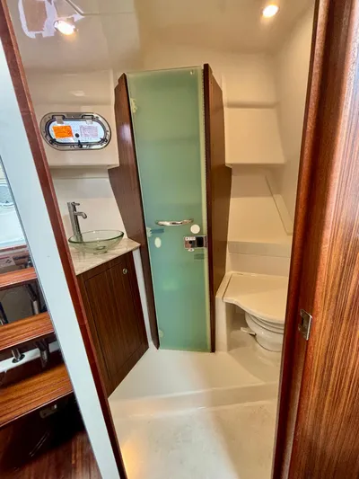  Yacht Photos Pics 2018 Pursuit OS 355 Offshore boat bathroom with glass sink, shower, and toilet.