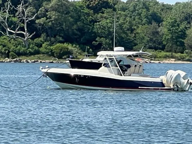  Yacht Photos Pics 2016 Chris-Craft 34 Catalina boat anchored on a serene lake with lush greenery.