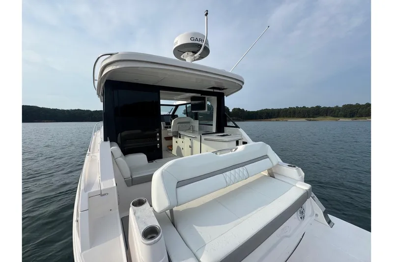  Yacht Photos Pics 2021 Regal 36 Grande Coupe yacht on serene water, showcasing luxurious seating and sleek design.