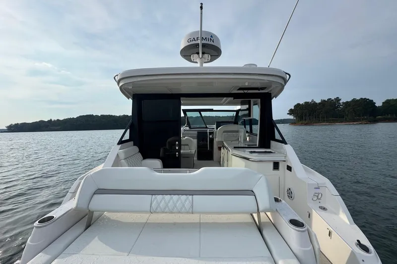  Yacht Photos Pics 2021 Regal 36 Grande Coupe yacht on serene water with lush shoreline.