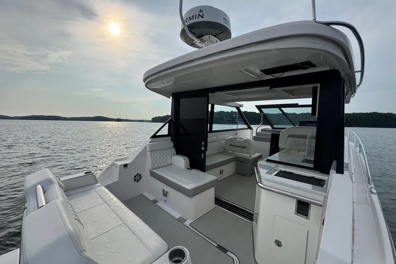  Yacht Photos Pics 2021 Regal 36 Grande Coupe boat interior on a serene lake at sunset.