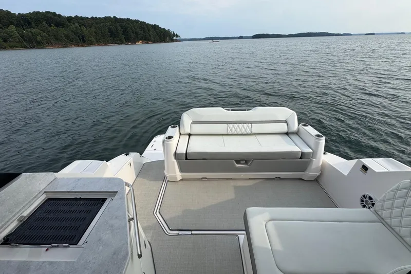  Yacht Photos Pics 2021 Regal 36 Grande Coupe boat with spacious seating, overlooking serene lake waters.