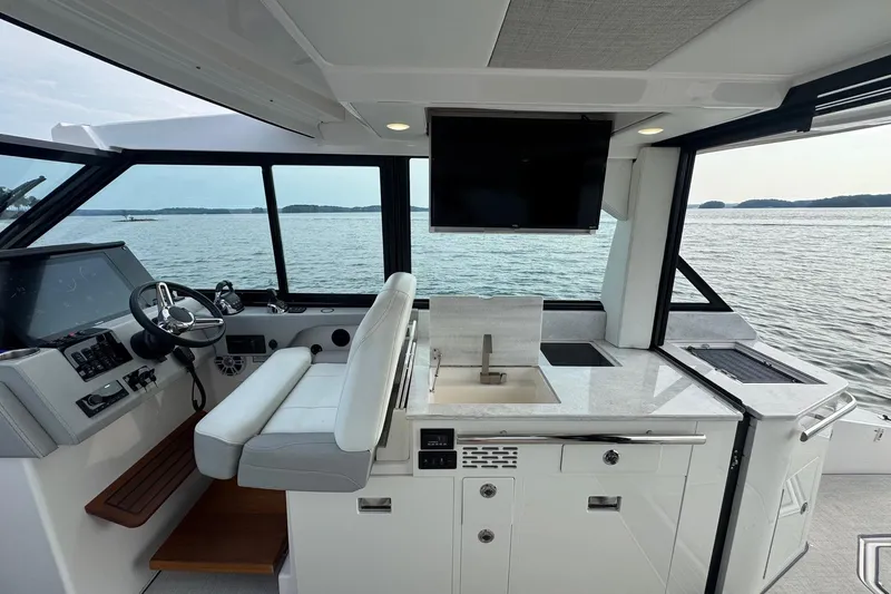  Yacht Photos Pics Interior of 2021 Regal 36 Grande Coupe yacht with helm, sink, and scenic water view.