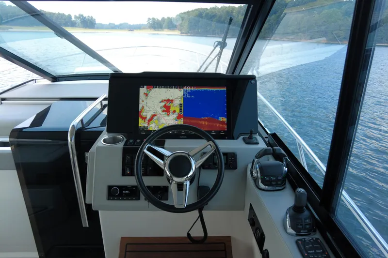  Yacht Photos Pics 2021 Regal 36 Grande Coupe helm with navigation display on a serene lake.