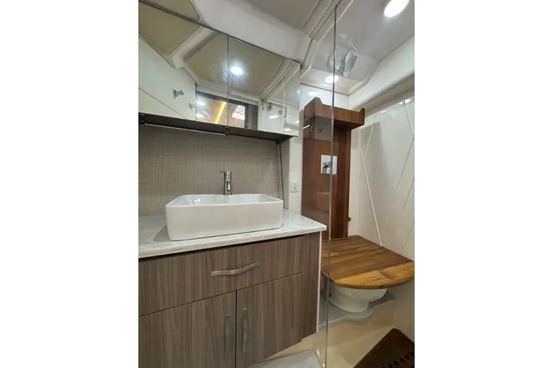  Yacht Photos Pics Luxurious bathroom in 2021 Regal 36 Grande Coupe yacht with modern sink and wooden accents.