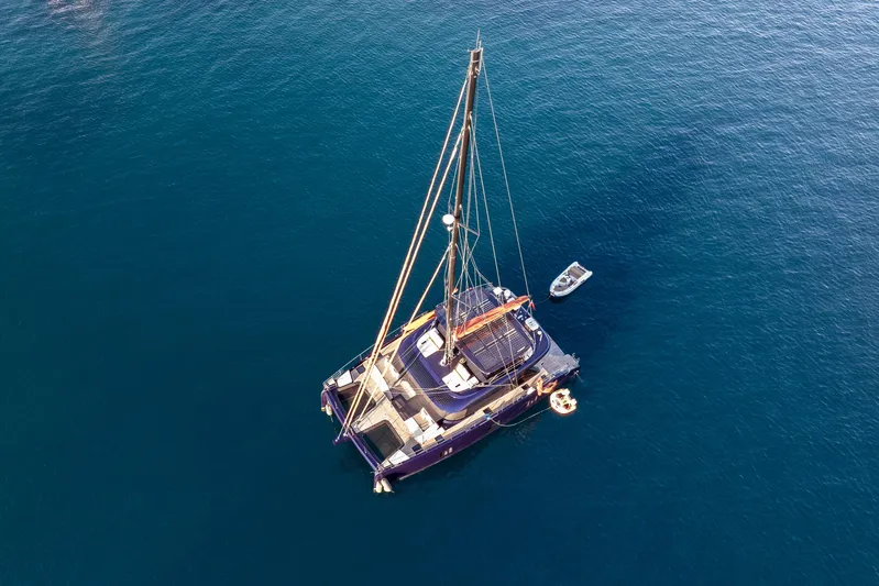  Yacht Photos Pics Aerial view of 2024 Sunreef 60 Eco catamaran on calm blue water.
