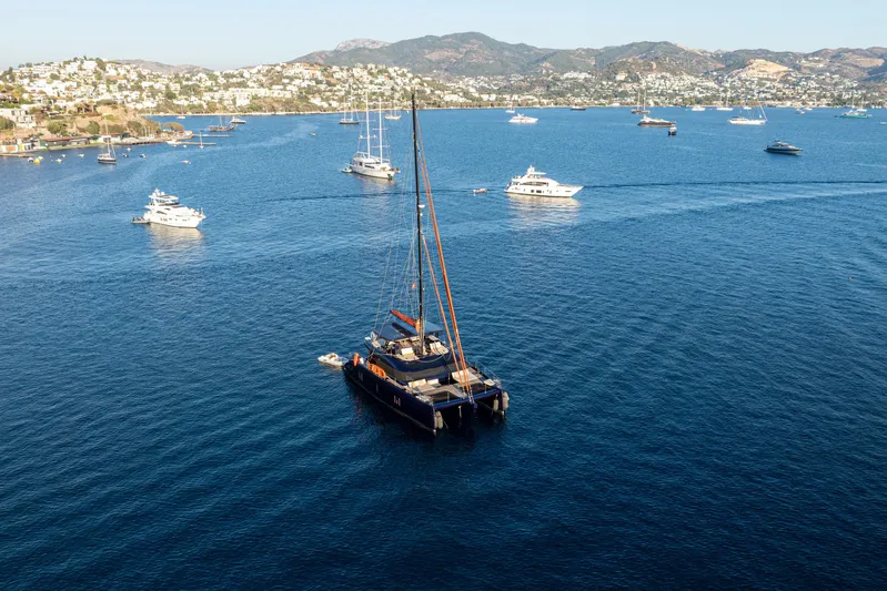  Yacht Photos Pics 2024 Sunreef 60 Eco yacht sailing in a scenic bay with other boats.