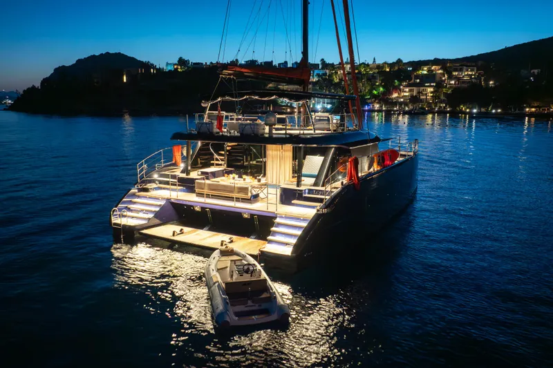  Yacht Photos Pics Luxurious 2024 Sunreef 60 Eco yacht illuminated at night, docked in serene waters.