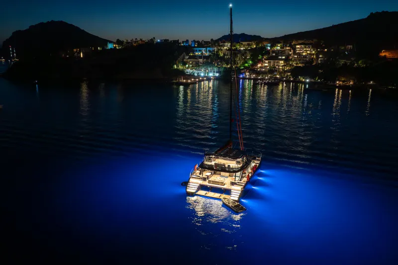  Yacht Photos Pics 2024 Sunreef 60 Eco yacht illuminated at night on serene waters.