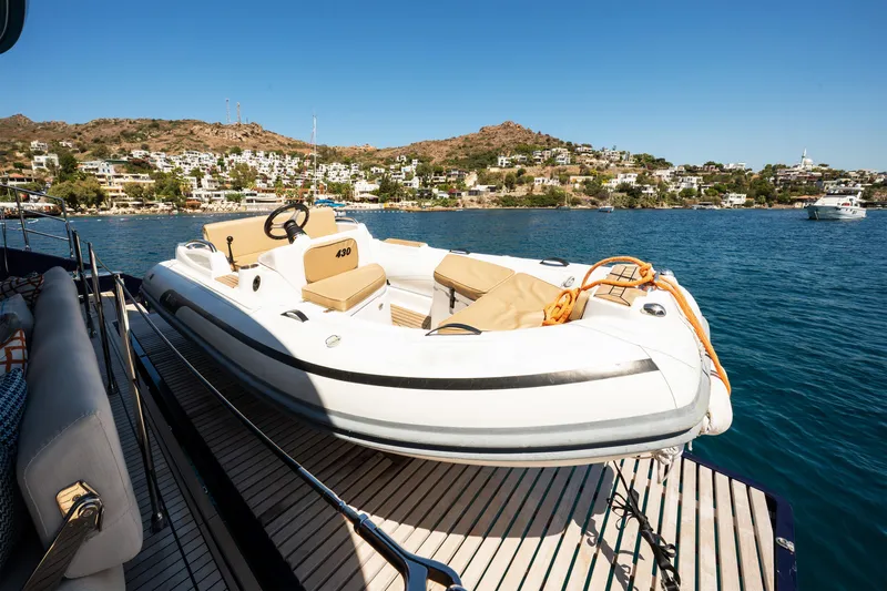  Yacht Photos Pics 2024 Sunreef 60 Eco yacht with inflatable boat on deck, scenic coastal view.