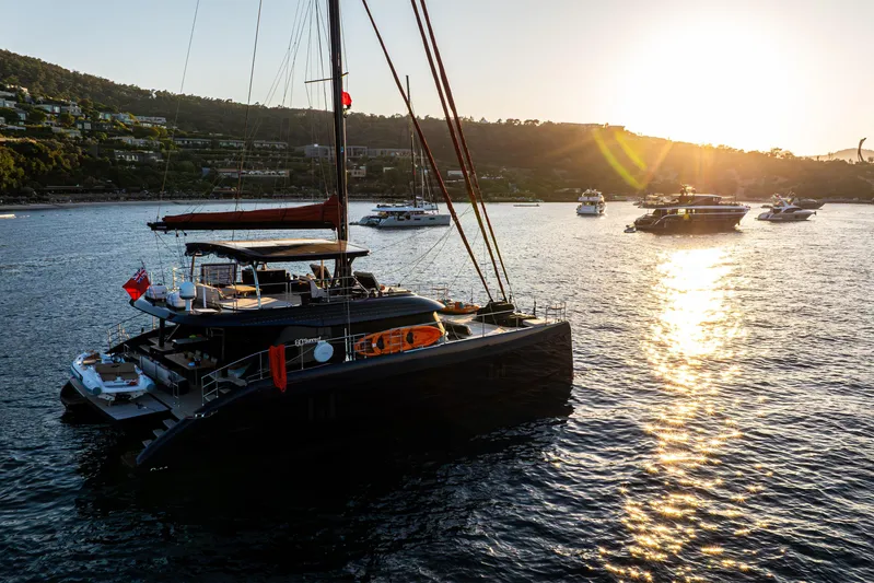  Yacht Photos Pics 2024 Sunreef 60 Eco yacht at sunset, anchored in a scenic bay.