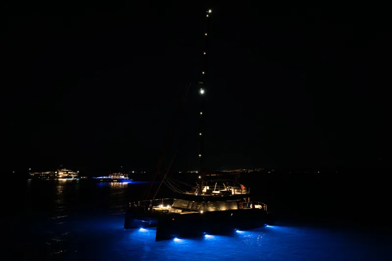  Yacht Photos Pics 2024 Sunreef 60 Eco yacht illuminated at night with blue underwater lights.