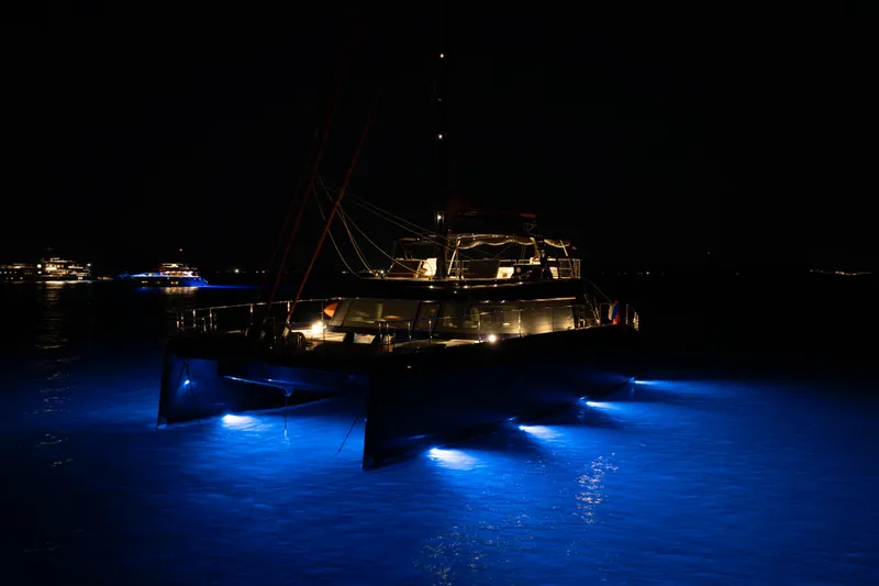  Yacht Photos Pics 2024 Sunreef 60 Eco yacht illuminated at night with blue underwater lights.