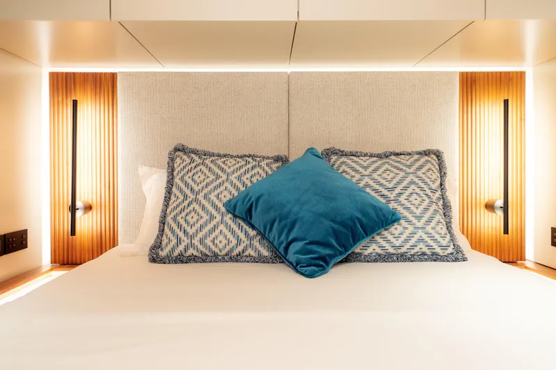  Yacht Photos Pics Luxurious bedroom interior of 2024 Sunreef 60 Eco yacht with stylish pillows and ambient lighting.