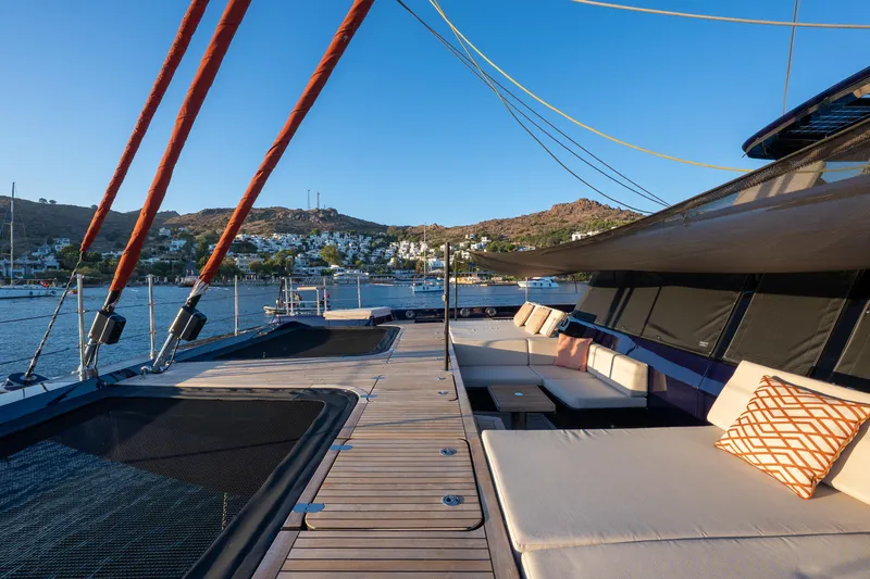  Yacht Photos Pics Luxurious 2024 Sunreef 60 Eco yacht deck with comfortable seating, scenic coastal view.
