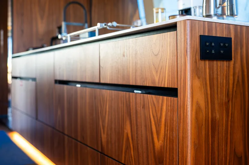  Yacht Photos Pics Luxurious wooden interior of 2024 Sunreef 60 Eco yacht kitchen with modern fixtures.