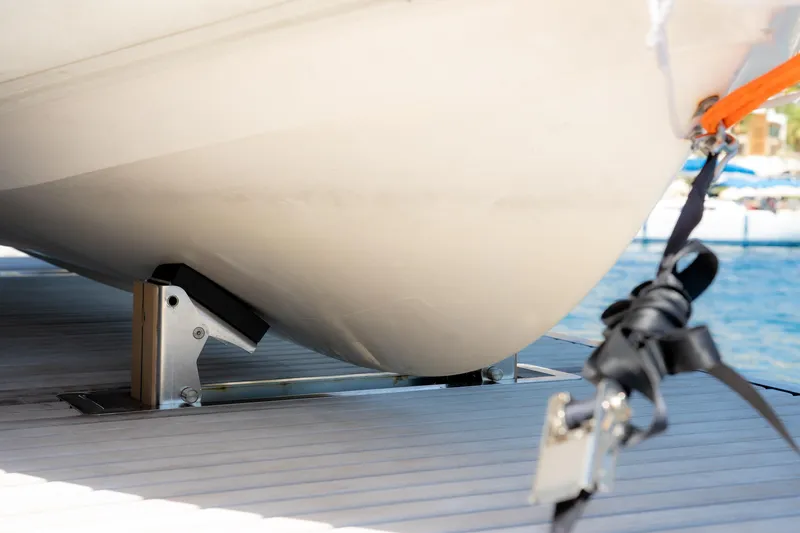  Yacht Photos Pics Close-up of 2024 Sunreef 60 Eco yacht hull on dock with securing straps.