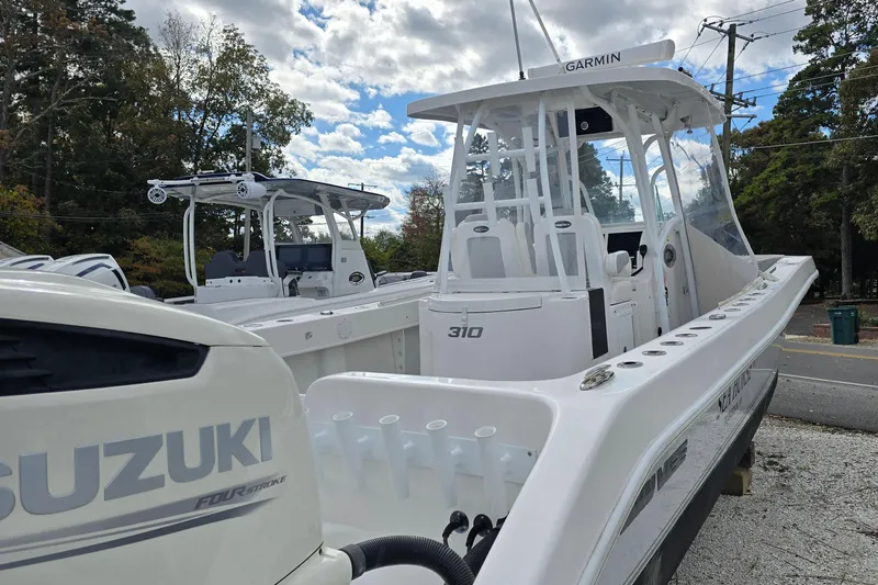  Yacht Photos Pics 2021 Twin Vee 310 CC GF boat with Suzuki engine, parked outdoors under cloudy sky.