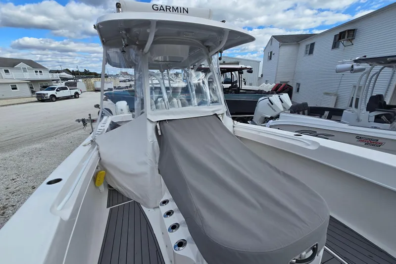  Yacht Photos Pics 2021 Twin Vee 310 CC GF boat with covered seating, docked under a cloudy sky.