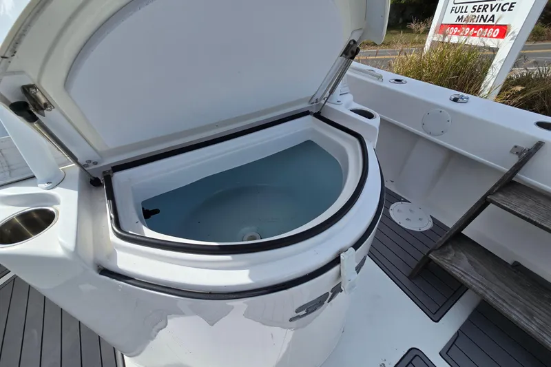  Yacht Photos Pics 2021 Twin Vee 310 CC GF boat with open livewell at marina.